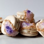 Geode Macarons laying on top of each other on a white surface