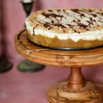 heath bar cheesecake on a wooden cake stand