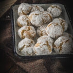 Soft amaretti cookies in a white container on a brown cloth