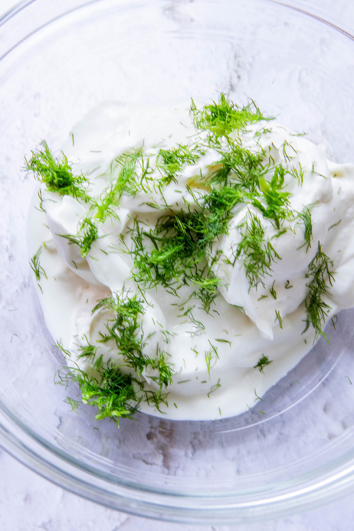 dill and yogurt in a glass bowl