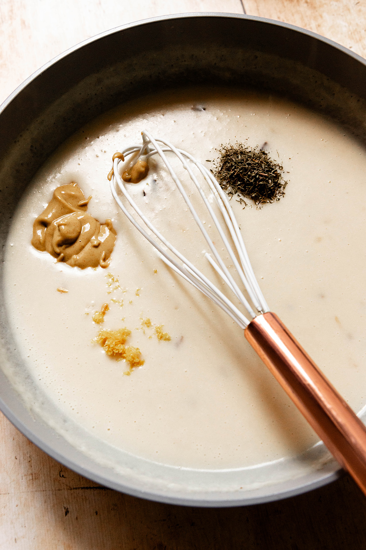 sauce in pan with spices and whisk