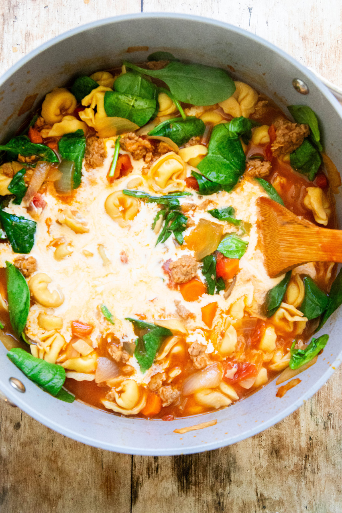 Creamy Vegetarian Tortellini Soup in a pot with cream and spinach