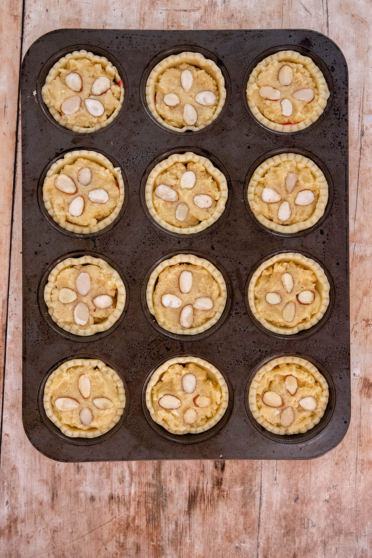 raspberry frangipane tartlets in a muffin tin