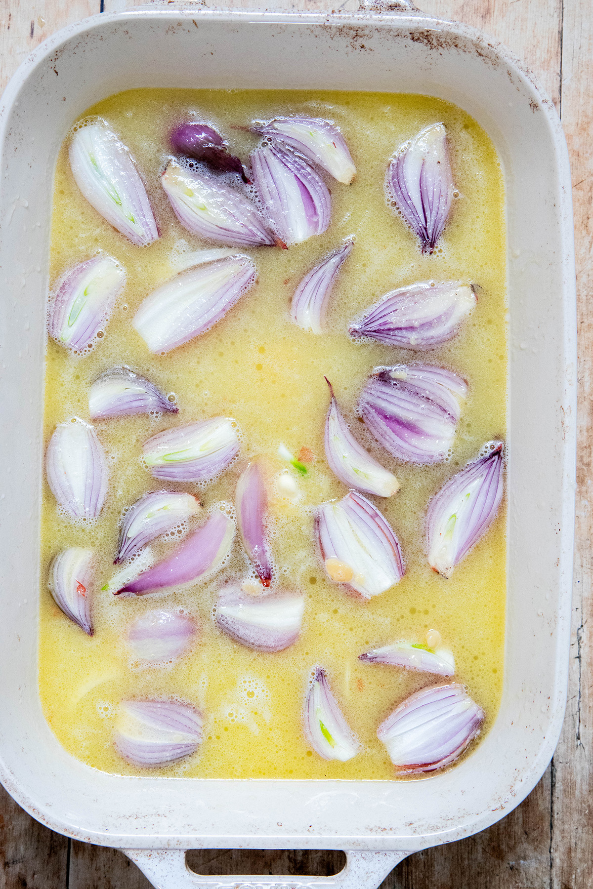 shallots in a miso butter broth in a baking dish